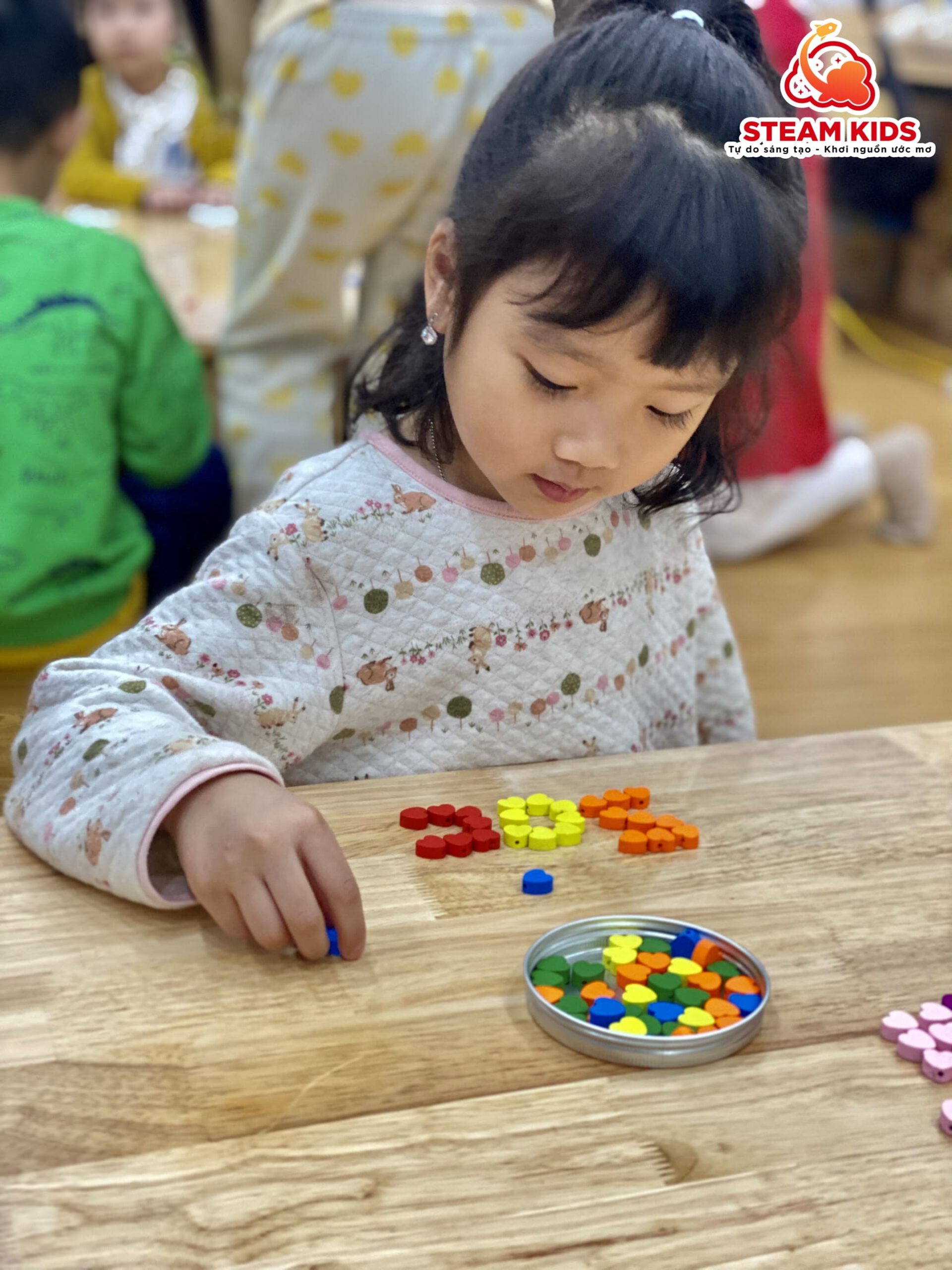 HOẠT ĐỘNG REGGIO: GHÉP CHỮ BẰNG NGUYÊN VẬT LIỆU GỖ, NẮP CHAI HỘT HẠT - Trường Mầm Non STEAM KIDS